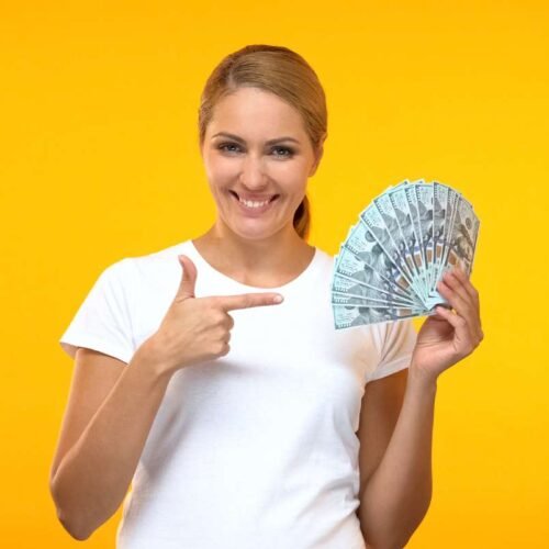 Women in yellow background showing money in hand